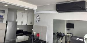 a kitchen with white cabinets and a clock on the wall at DURBAN BEACHFRONT Tenbury 903 in Durban
