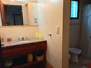 a bathroom with a sink and a mirror and a toilet at Arcadia in Merlo +36 photos