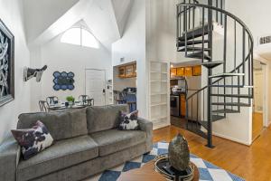 a living room with a couch and a spiral staircase at Austin Apartments by Andes STR in Austin