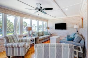 a living room with two chairs and a ceiling fan at Hazel Q in Edisto Island