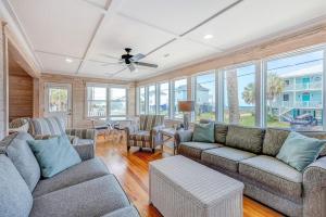 a living room with couches and chairs and windows at Hazel Q in Edisto Island