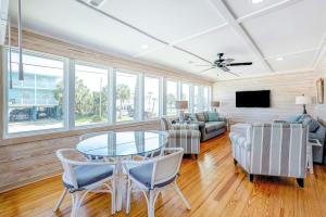 a living room with a glass table and chairs at Hazel Q in Edisto Island +29 photos