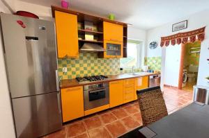 a kitchen with orange cabinets and a stainless steel refrigerator at Villa Malnar in Vrh