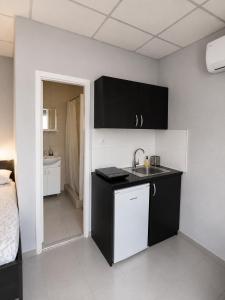 a kitchen with black cabinets and a sink in a room at Apartman za 6 osoba BOR in Bor