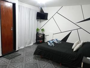 ein Schlafzimmer mit einem schwarzen Bett in einem Zimmer in der Unterkunft Suite Munro in Munro
