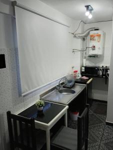 eine kleine Küche mit Spüle und Tisch in der Unterkunft Suite Munro in Munro