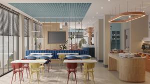 a restaurant with tables and chairs and a tv at Holiday Inn Express Yalova by IHG in Yalova