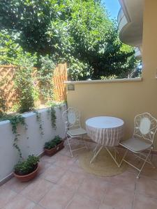 a patio with two chairs and a table at Salento Garden Relax in Merine +6 photos