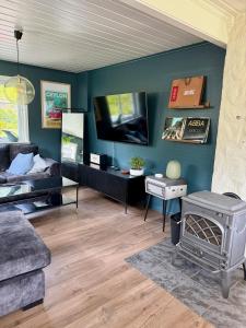 a living room with a couch and a flat screen tv at Scenic Private House Surrounded by Nature in Sæbø