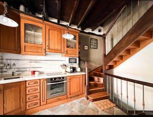 a kitchen with wooden cabinets and a spiral staircase at LITTLE TOWER in Potes