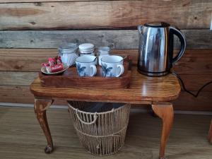a table with a coffee pot and mugs on it at Brynhyfryd in Llanaelhaiarn