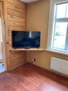 a television sitting on a shelf in a room with two windows at Ligzdiņas in Bernāti