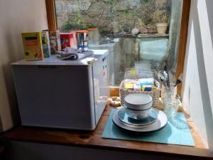 a microwave sitting on a table with a bowl on a plate at Brynhyfryd in Llanaelhaiarn