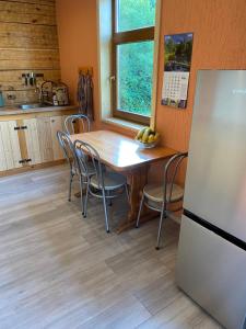 a kitchen with a table and chairs and a refrigerator at Ligzdiņas in Bernāti