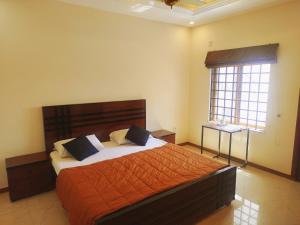 a bedroom with a bed with orange sheets and a window at The Warmer House Islamabad Airport in Islamabad