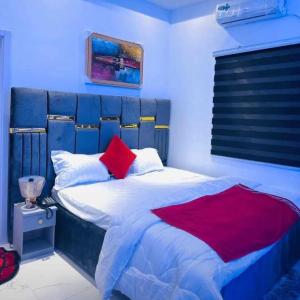 a bedroom with a bed with a blue headboard at MyTime Hotel in Tamale