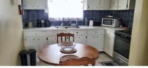 a small kitchen with a wooden table and a microwave at Sailor's Gem in Tortola Island +5 photos