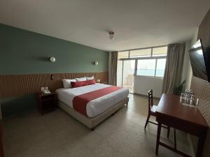 a bedroom with a bed and a desk and a window at Hotel Royalty in Veracruz