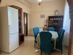 a kitchen with a table and blue chairs and a refrigerator at Rose Garden in Siófok +17 photos