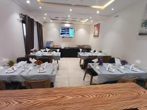 a dining room with tables and chairs and a stage at Hotel Occazia Lubumbashi in Lubumbashi