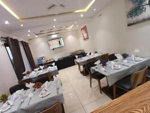 a dining room with tables and chairs in a room at Hotel Occazia Lubumbashi in Lubumbashi