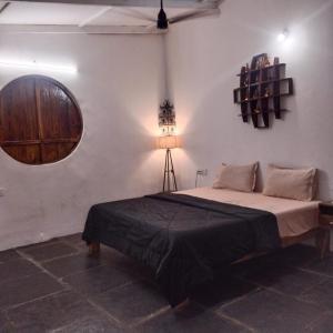 a bedroom with a bed and a round window at Villa Saffron Luxury Pvt Pool in Pondicherry +19 photos