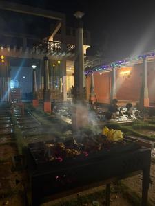 a grill with smoke in front of a building at night at Villa Saffron Luxury Pvt Pool in Pondicherry