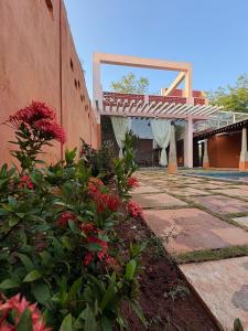 a building with a walkway and flowers in front of it at Villa Saffron Luxury Pvt Pool in Pondicherry