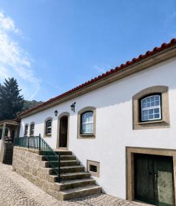 a white building with stairs and a door at Valadouro Dona Adelaïde With a Pool in Espinhosa