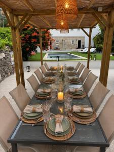 a long table with plates and glasses and candles at Valadouro Dona Adelaïde With a Pool in Espinhosa