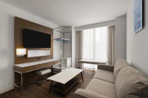 a living room with a couch and a tv at Best Western Premier Empire State Hotel in New York