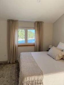a bedroom with a large bed and a window at Villa Ljeto in Pupnatska Luka