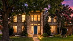 a brick house with a tree in front of it at Stylish Oasis Modern Living in Allen