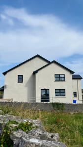 a large white house on top of a field at Dwellinghouse, Inishmore in Ourtnagapple