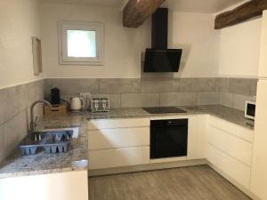 a kitchen with a sink and a stove top oven at Gîte La Carole 120m2 in Monlezun