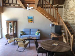 a living room with a blue couch and a table at Gîte La Carole 120m2 in Monlezun