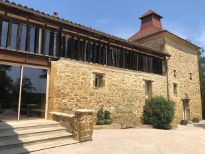 a large stone building with a large window at Gîte La Carole 120m2 in Monlezun