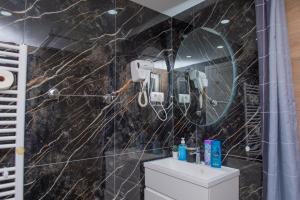 a bathroom with a black marble wall at Apartman Živković in Leskovac +63 photos