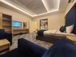 a hotel room with two beds and a flat screen tv at sala almasa serviced apartments in Abha