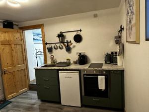 a kitchen with a sink and a stove top oven at Stardust Getaway Tiny-Home E32AK40 in Piltown