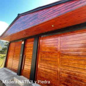 a pair of wooden garage doors on a building at OXALAND HAUs in Oxapampa
