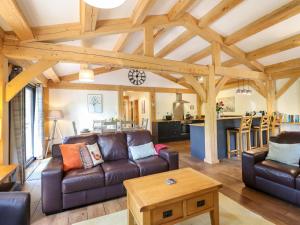 a living room with leather couches and a table at Lady Bagots Cabin in Ruthin