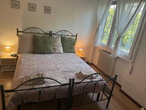 a bedroom with a metal bed with two windows at Residence ai Melograni II in Silea +3 photos