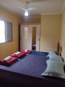 a large bed with two red pillows on top of it at Casa na área central com 3 quartos in São Pedro +43 photos