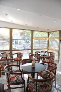 un restaurant avec des tables, des chaises et des fenêtres dans l'établissement Elements Rooms & Apartments, à Athènes