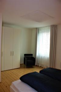 1 dormitorio con 1 cama, armario y silla en Design Fewo am Harz, en Langelsheim