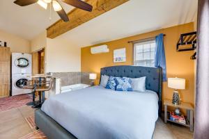 a bedroom with a blue bed and a kitchen at Cute Studio Cabin Steps to Long Beach Boardwalk in Long Beach