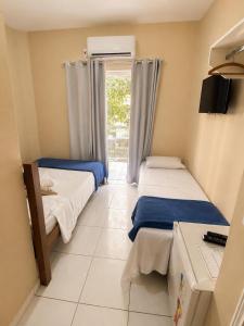 a small room with two beds and a window at Caminho do Mar Hotel in Guarujá +27 photos