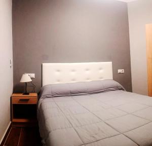 a bedroom with a bed with a white headboard at Apartamento El Centro in Algarrobo