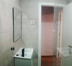 a white bathroom with a sink and a mirror at Apartamento El Centro in Algarrobo